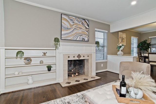 living area featuring a tile fireplace, dark hardwood / wood-style floors, and ornamental molding