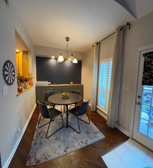 dining area featuring dark hardwood / wood-style flooring and a chandelier