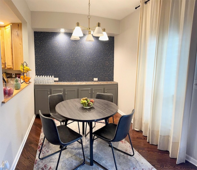 dining area with dark wood-type flooring and a chandelier