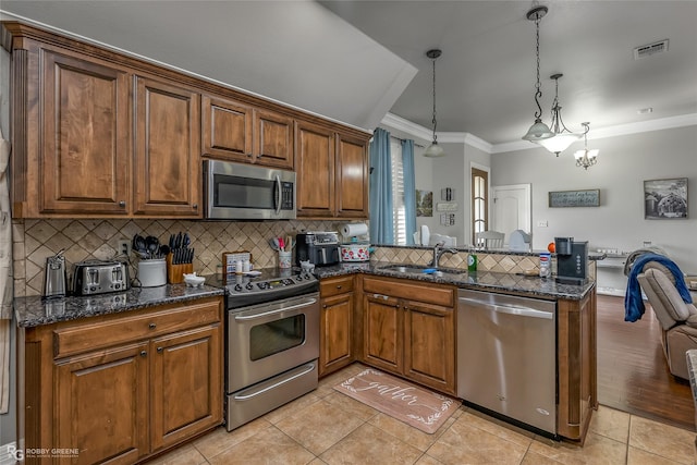 kitchen featuring stainless steel appliances, sink, hanging light fixtures, kitchen peninsula, and light tile patterned floors