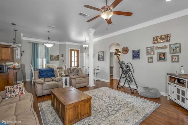 living room with dark hardwood / wood-style floors, ceiling fan with notable chandelier, ornamental molding, and ornate columns