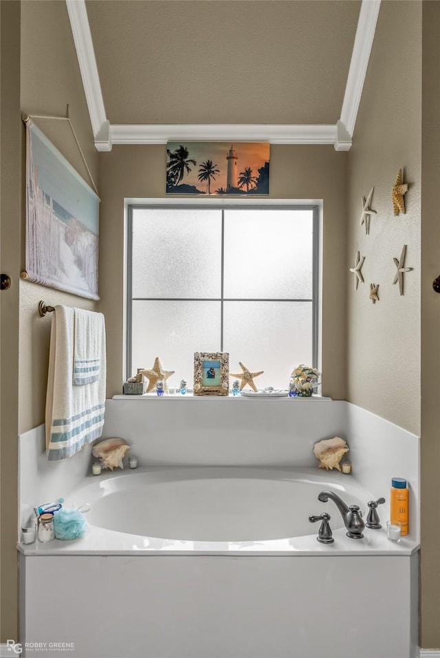 bathroom with ornamental molding, a tub to relax in, and plenty of natural light