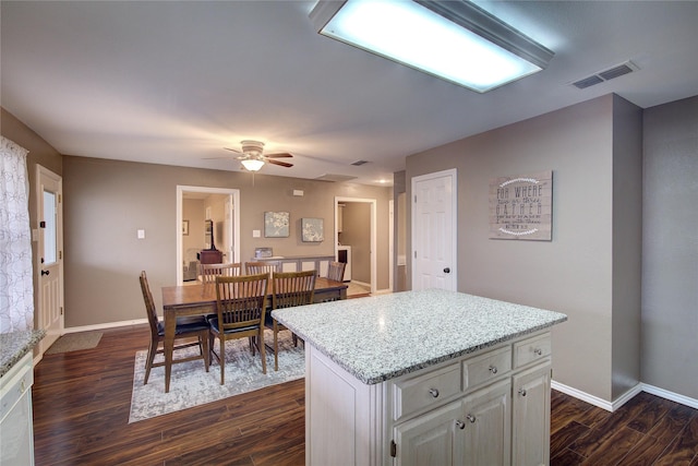 kitchen featuring ceiling fan, dishwasher, a center island, dark wood-type flooring, and white cabinets