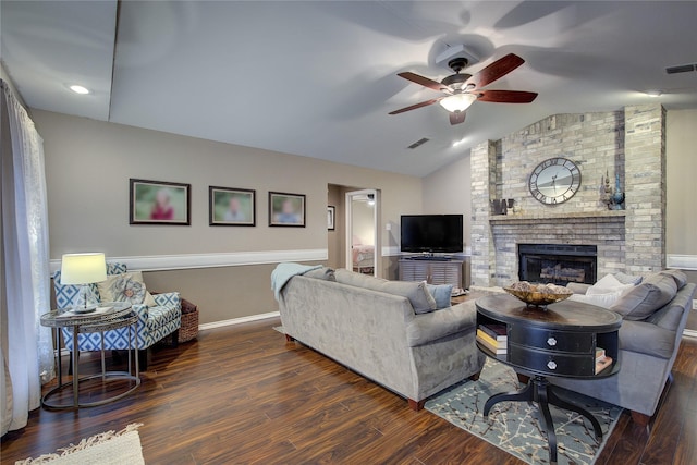 living room featuring a brick fireplace, lofted ceiling, dark hardwood / wood-style floors, and ceiling fan