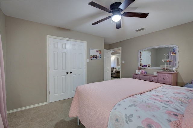 bedroom with ceiling fan, a closet, and light carpet