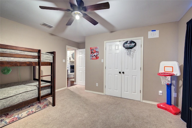 bedroom featuring ceiling fan, light colored carpet, and a closet