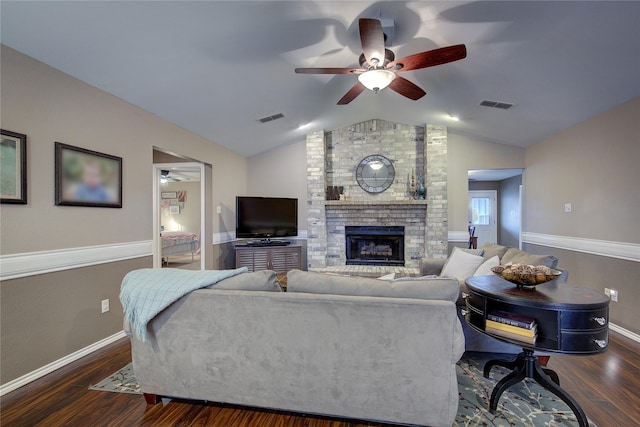 living room with ceiling fan, vaulted ceiling, dark hardwood / wood-style flooring, and a fireplace