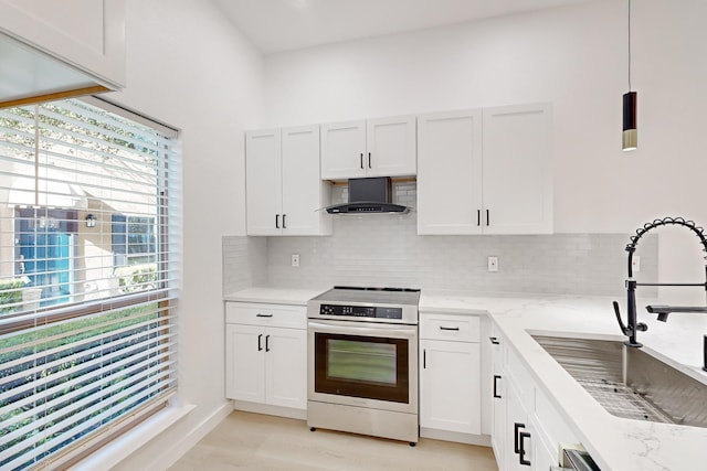 kitchen with wall chimney range hood, sink, hanging light fixtures, stainless steel range with electric cooktop, and white cabinets