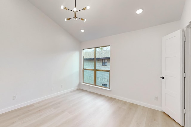 unfurnished room with light wood-type flooring, a chandelier, and vaulted ceiling