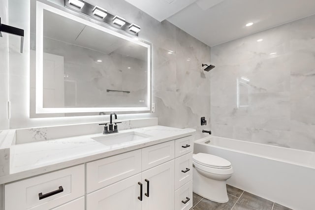 full bathroom with tiled shower / bath combo, tile patterned flooring, vanity, tile walls, and toilet