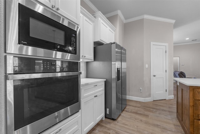 kitchen with white cabinetry, stainless steel appliances, crown molding, and light wood-type flooring