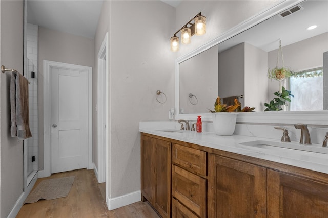 bathroom with hardwood / wood-style flooring, vanity, and a shower with shower door