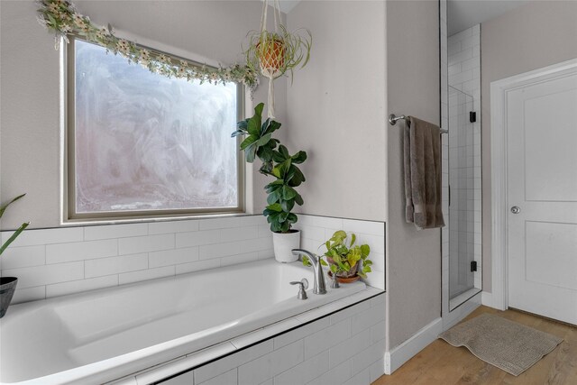 bathroom with hardwood / wood-style flooring, plus walk in shower, and a healthy amount of sunlight