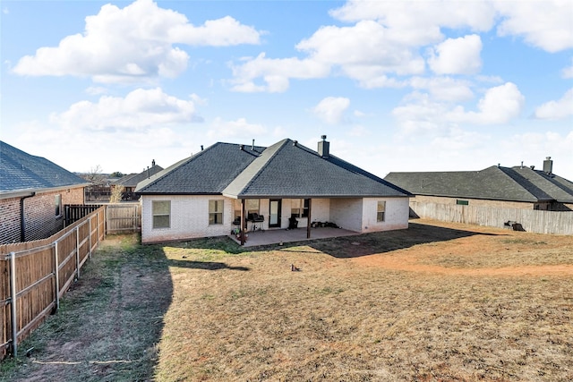 rear view of house featuring a patio area and a lawn