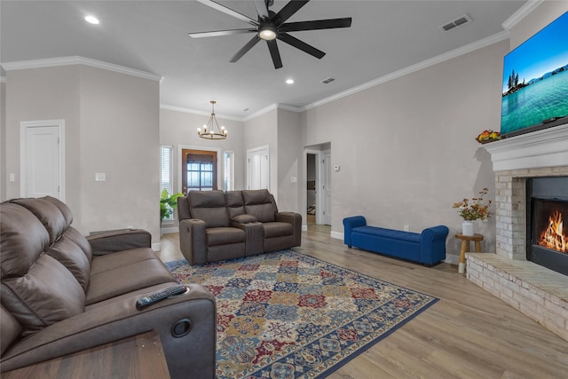 living room with a fireplace, ornamental molding, and light wood-type flooring