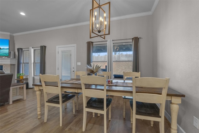 dining room with ornamental molding, hardwood / wood-style floors, and a notable chandelier