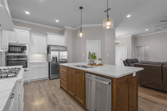 kitchen with sink, white cabinetry, a center island with sink, appliances with stainless steel finishes, and light stone countertops