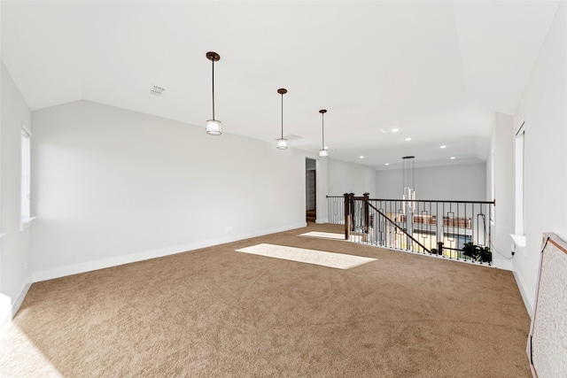 carpeted empty room featuring vaulted ceiling