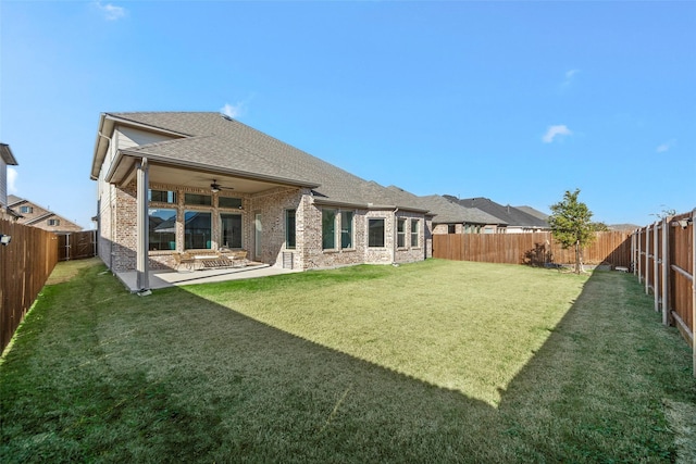 back of property with ceiling fan, a patio area, and a yard