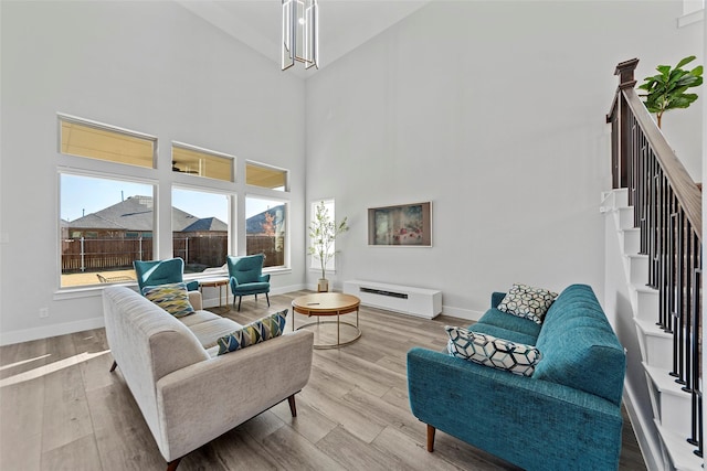 living room featuring a high ceiling and light hardwood / wood-style flooring