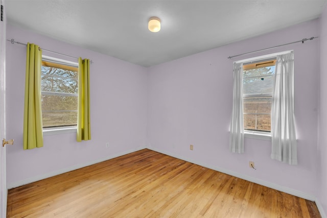 empty room with a healthy amount of sunlight and hardwood / wood-style flooring