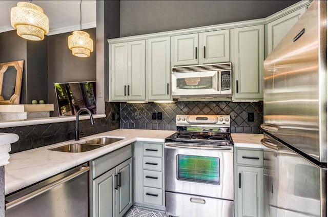 kitchen featuring pendant lighting, stainless steel appliances, decorative backsplash, sink, and light stone counters