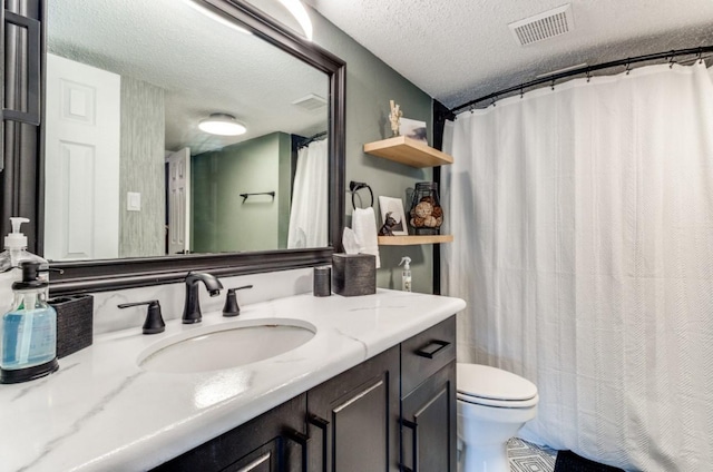 bathroom with a textured ceiling, toilet, and vanity