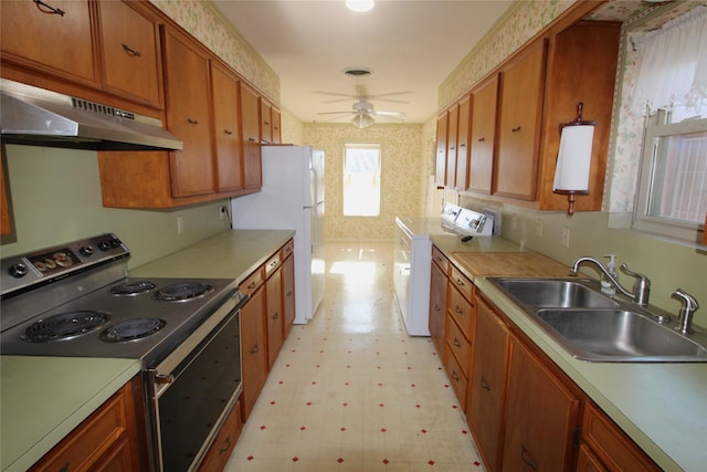 kitchen with sink, ceiling fan, stainless steel range with electric stovetop, white refrigerator, and washer / clothes dryer