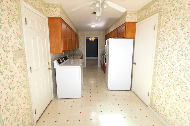 kitchen featuring white fridge, washer and dryer, sink, and ceiling fan