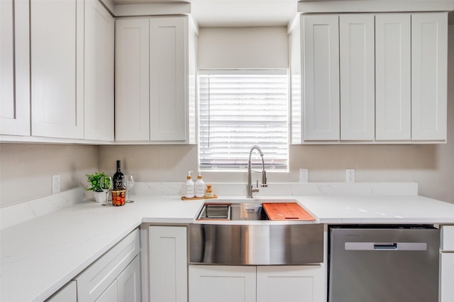 kitchen with light stone counters, white cabinets, sink, and dishwasher