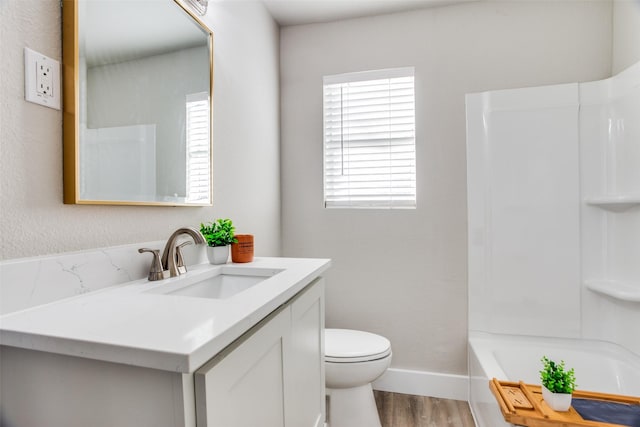 full bathroom with hardwood / wood-style flooring, vanity, toilet, and shower / washtub combination