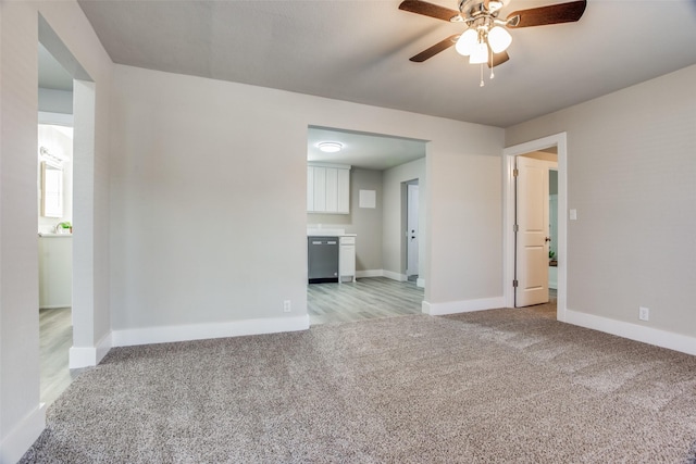 empty room featuring ceiling fan and light carpet