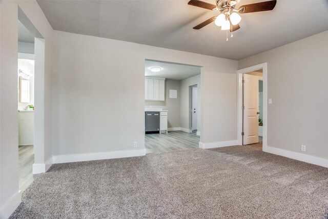 unfurnished living room with light carpet, ceiling fan, and sink