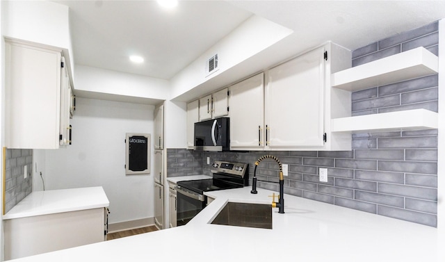 kitchen with electric stove, tasteful backsplash, sink, white cabinetry, and hardwood / wood-style flooring