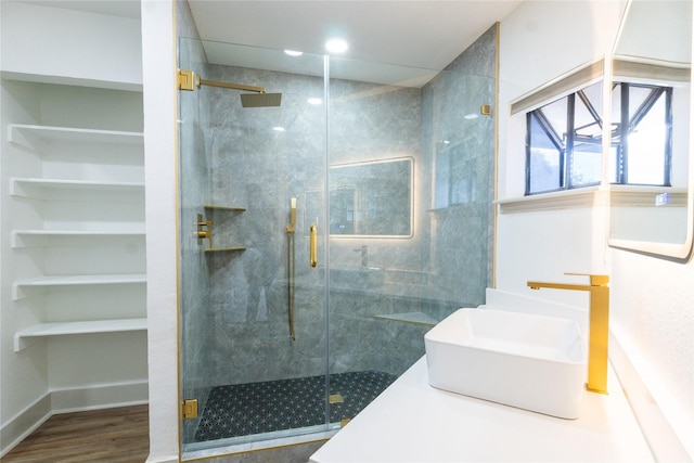 bathroom with a shower with shower door, wood-type flooring, and sink