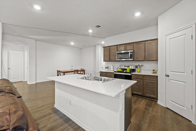 kitchen with dark wood-type flooring, sink, a center island with sink, and stainless steel appliances