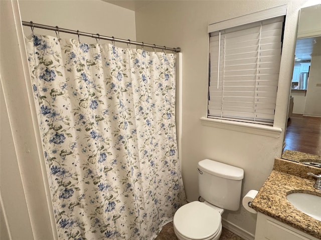 bathroom with toilet, vanity, and a shower with curtain