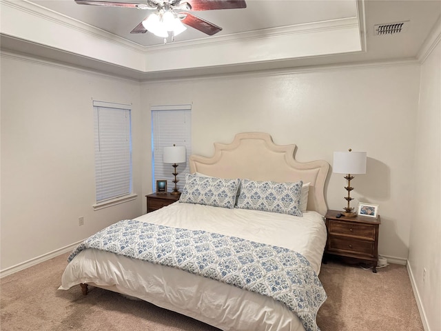 carpeted bedroom featuring ceiling fan, crown molding, and a tray ceiling