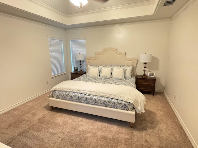 carpeted bedroom with ceiling fan, a tray ceiling, and crown molding