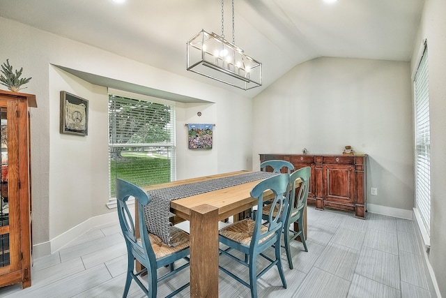 dining space with vaulted ceiling and an inviting chandelier