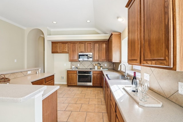 kitchen featuring lofted ceiling, stainless steel appliances, decorative backsplash, sink, and light tile patterned floors