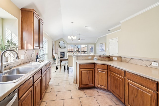 kitchen with vaulted ceiling, dishwasher, decorative light fixtures, sink, and light tile patterned flooring