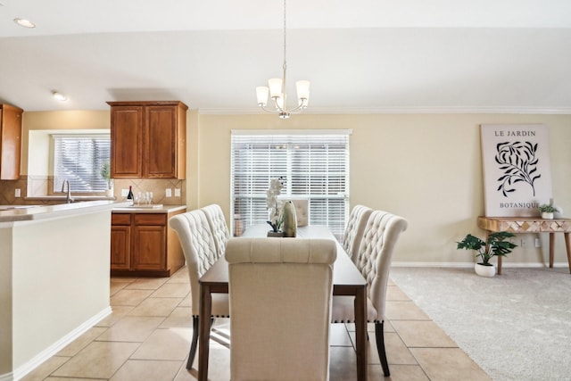 tiled dining space featuring a notable chandelier and ornamental molding