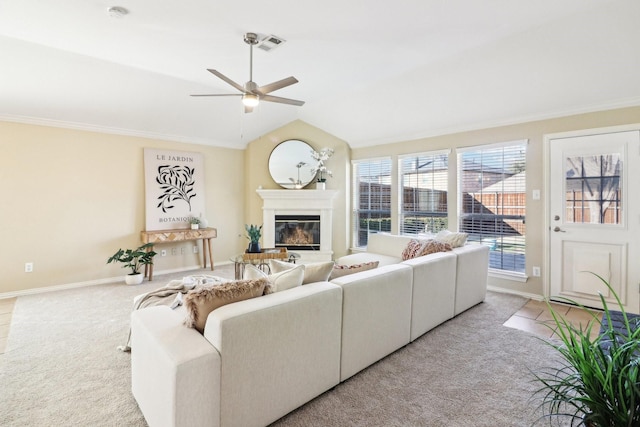 living room featuring vaulted ceiling, ceiling fan, ornamental molding, and light colored carpet