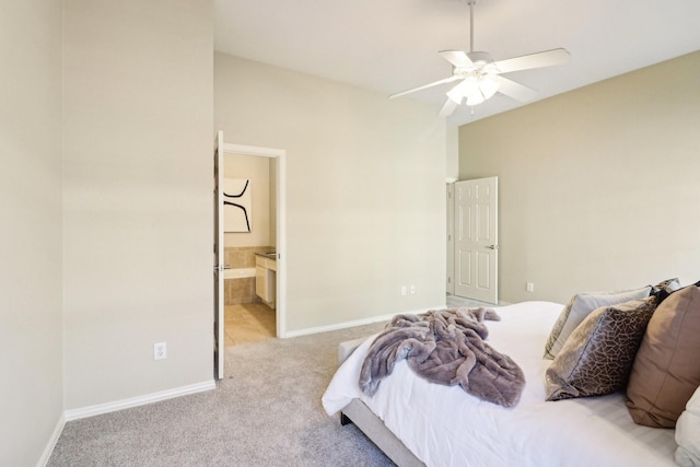 bedroom with ceiling fan, light carpet, and connected bathroom