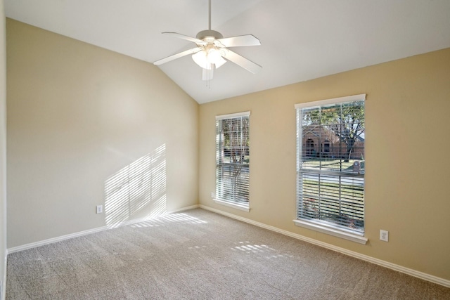 empty room featuring ceiling fan, lofted ceiling, and carpet floors