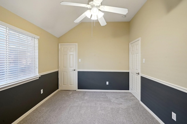 carpeted spare room with ceiling fan and lofted ceiling