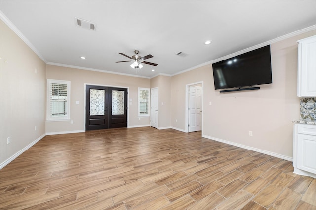 entryway with ceiling fan, crown molding, and french doors