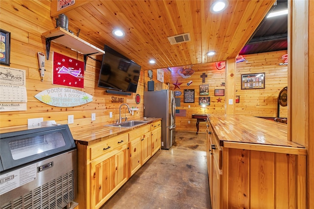 kitchen featuring stainless steel fridge, wood walls, wooden counters, wooden ceiling, and sink