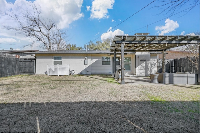 rear view of property with a patio and a lawn